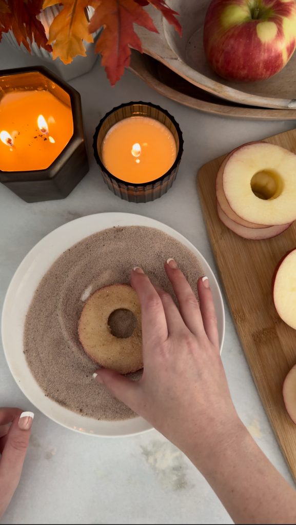 These Apple Cinnamon Pastry Donuts are filled with fresh apple slices, surrounded by puff pastry, covered in cinnamon sugar, drizzled with caramel sauce, and topped with a cinnamon stick and edible maple leaf.