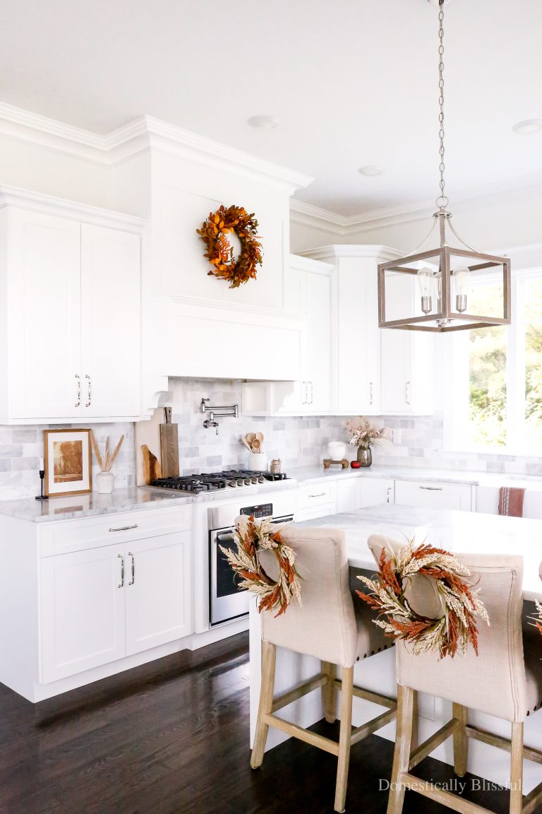 Simple Fall Kitchen Decor with hints of orange, brown, and red throughout with fall prints, fresh apples, and gorgeous stems.