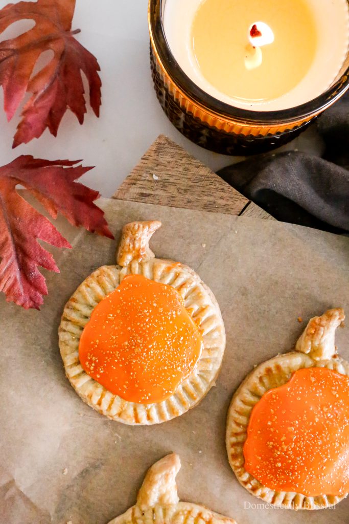 These Homemade Pumpkin Pop Tarts are made with pie crust and have a sweet pumpkin filling topped with orange icing and sprinkles, making them perfect for a fall party or Thanksgiving brunch.