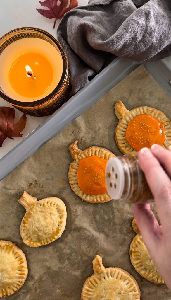 These Homemade Pumpkin Pop Tarts are made with pie crust and have a sweet pumpkin filling topped with orange icing and sprinkles, making them perfect for a fall party or Thanksgiving brunch.