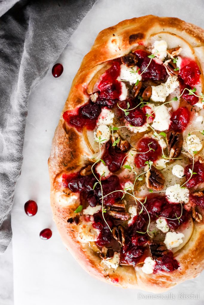 This Cranberry Pear Flatbread is topped with goat cheese, fresh pear, cranberry sauce, and pecans, making it a delicious Christmas appetizer or Thanksgiving leftover recipe.