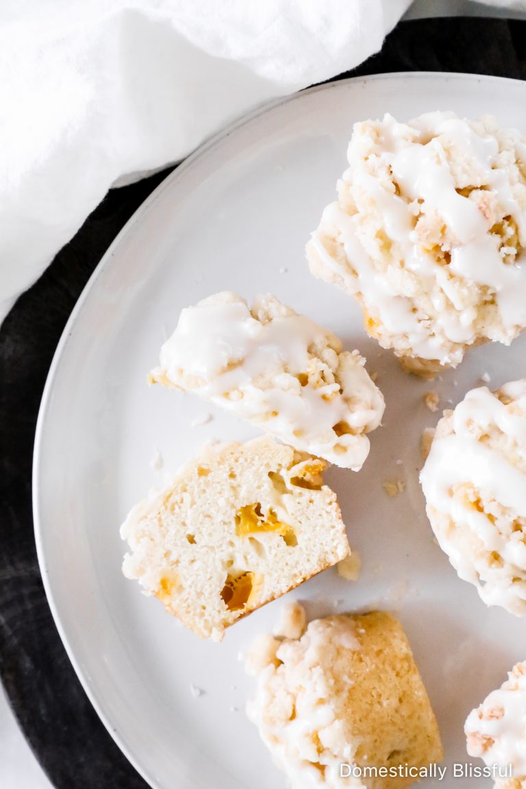 These Crumble Peach Muffins are filled with fresh peaches and topped with a sweet streusel crumble topping and a drizzle of icing.