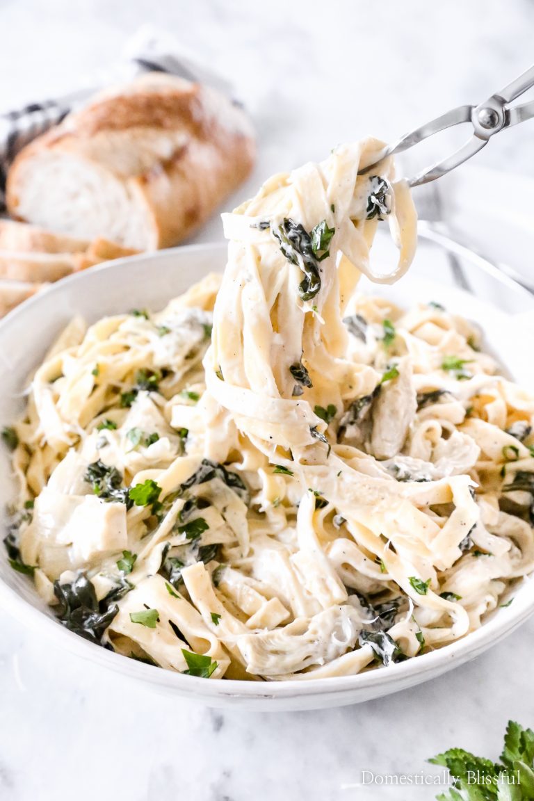 This Spinach Artichoke Fettuccini is made with fresh fettuccini topped with a creamy sauce filled with marinated artichoke hearts and spinach and topped with fresh parsley and grated parmesan.