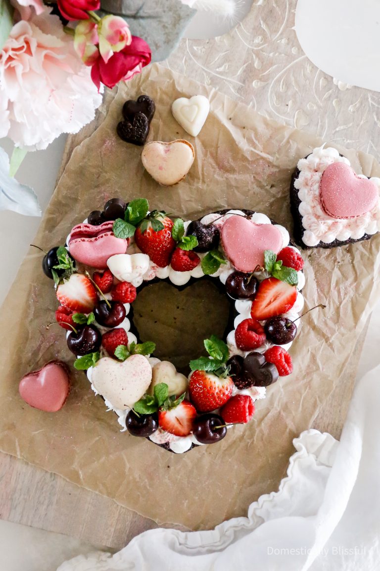 This Valentine's Heart Brownie is a fun way to decorate a brownie with frosting, fruit, heart macaroons, chocolate, mint, and edible glitter.
